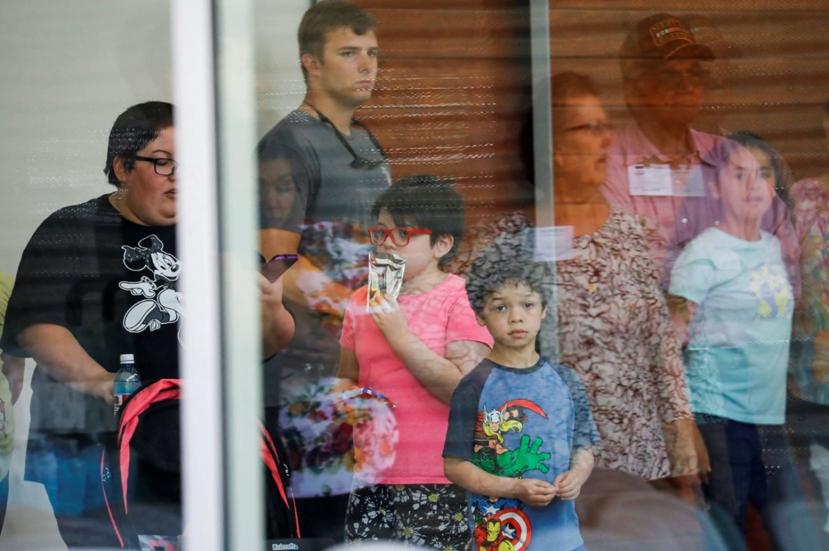 Các học sinh nhìn qua cửa kính tại Trung tâm Ssgt Willie de Leon, nơi các em được đưa tới sau vụ xả súng ở trường tiểu học Robb.