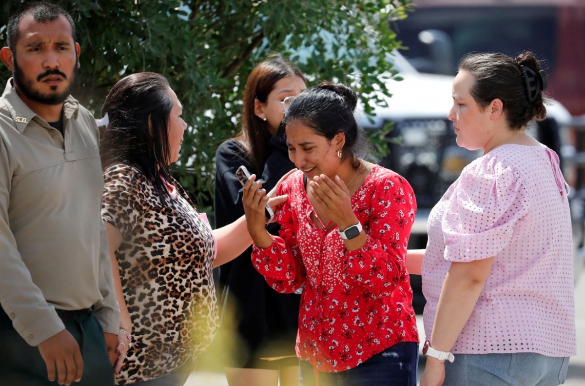 Một người phụ nữ bật khóc khi chứng kiến hậu quả của vụ xả súng.