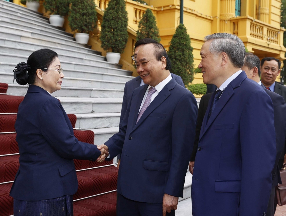 State President nguyen Xuan Phuc (second from right) shakes hands with Viengthong Siphandone, president of the Lao People’s Supreme Court in Hanoi on May 13.