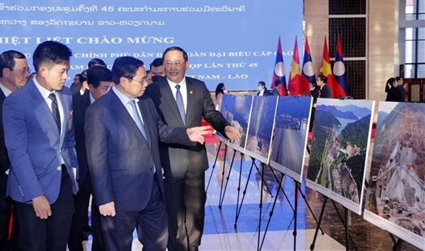 pms of vietnam, laos visit photo exhibition on achievements of economic ties picture 1