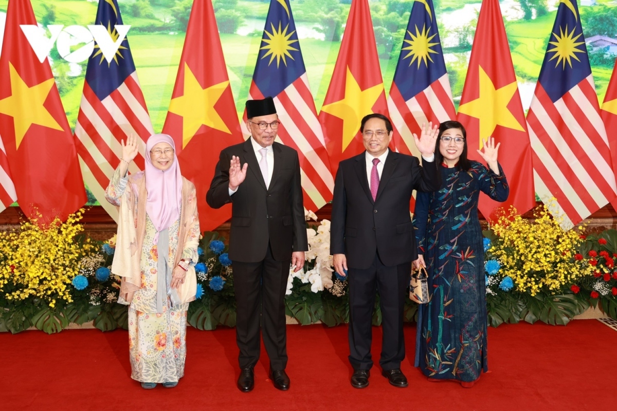 The two leaders and their wives take a photo together.