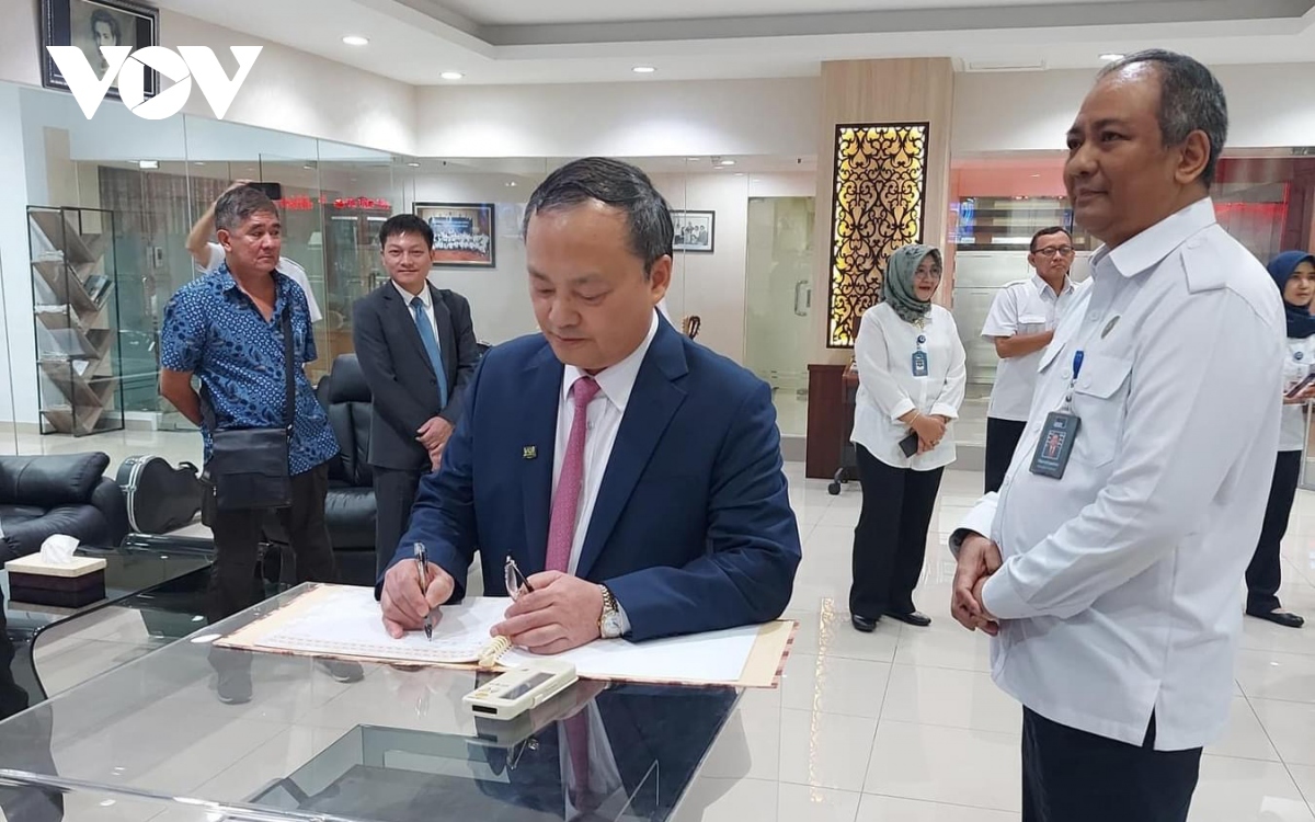 President of VOV Do Tien Sy writes a note on a souvenir book at the headquarters of RRI.