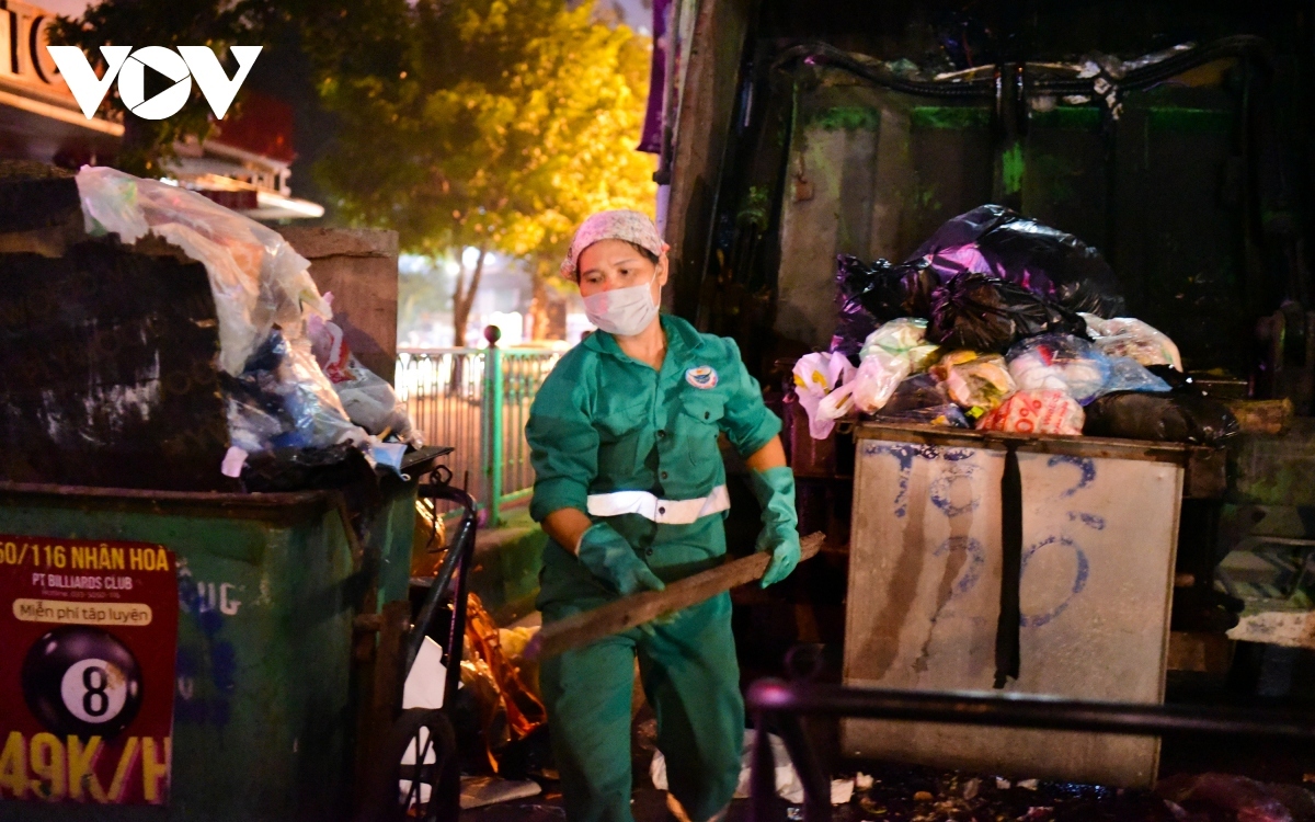 It is common to see people in sanitation uniforms working late at night in Hanoi.