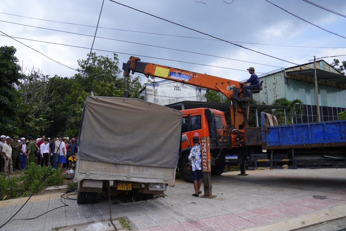 Xe tải kéo lê người phụ nữ đi xe máy lên vỉa hè