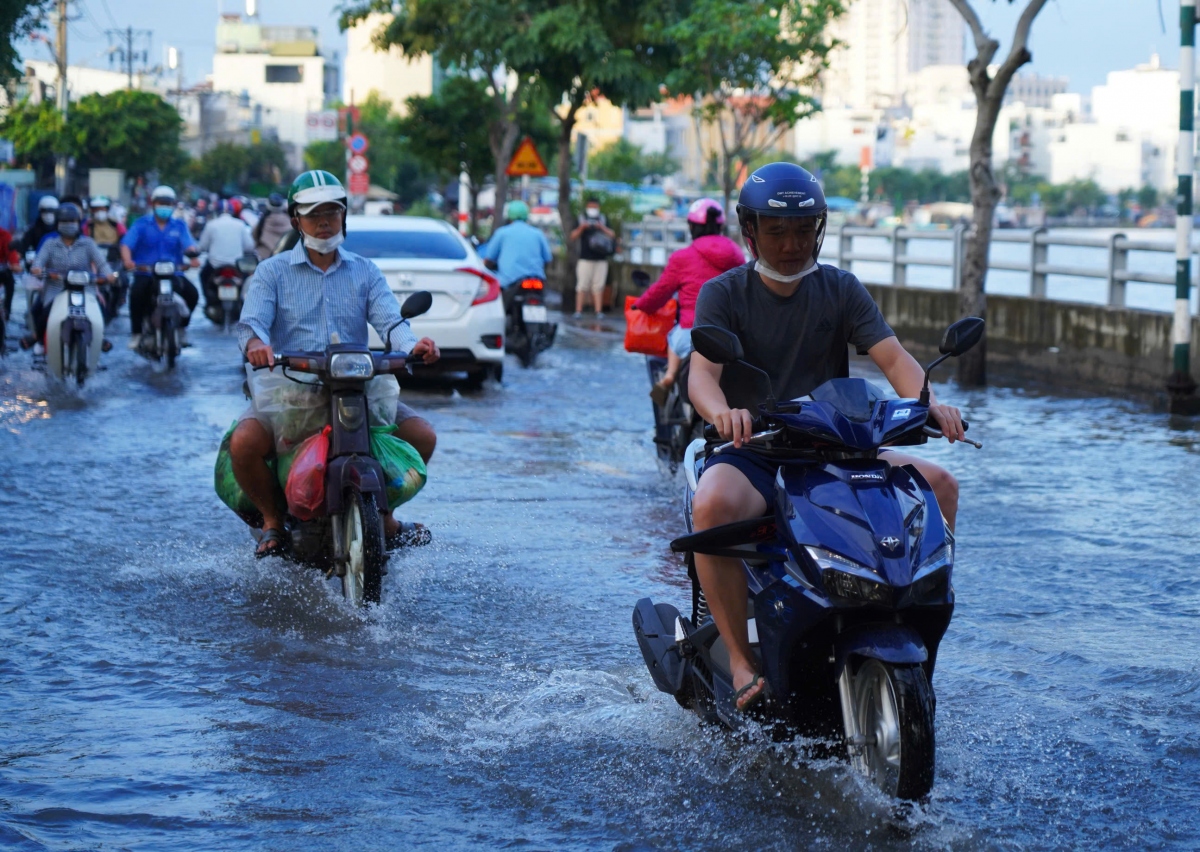 Triều cường đạt đỉnh, người dân TP.HCM chật vật di chuyển trên biển nước