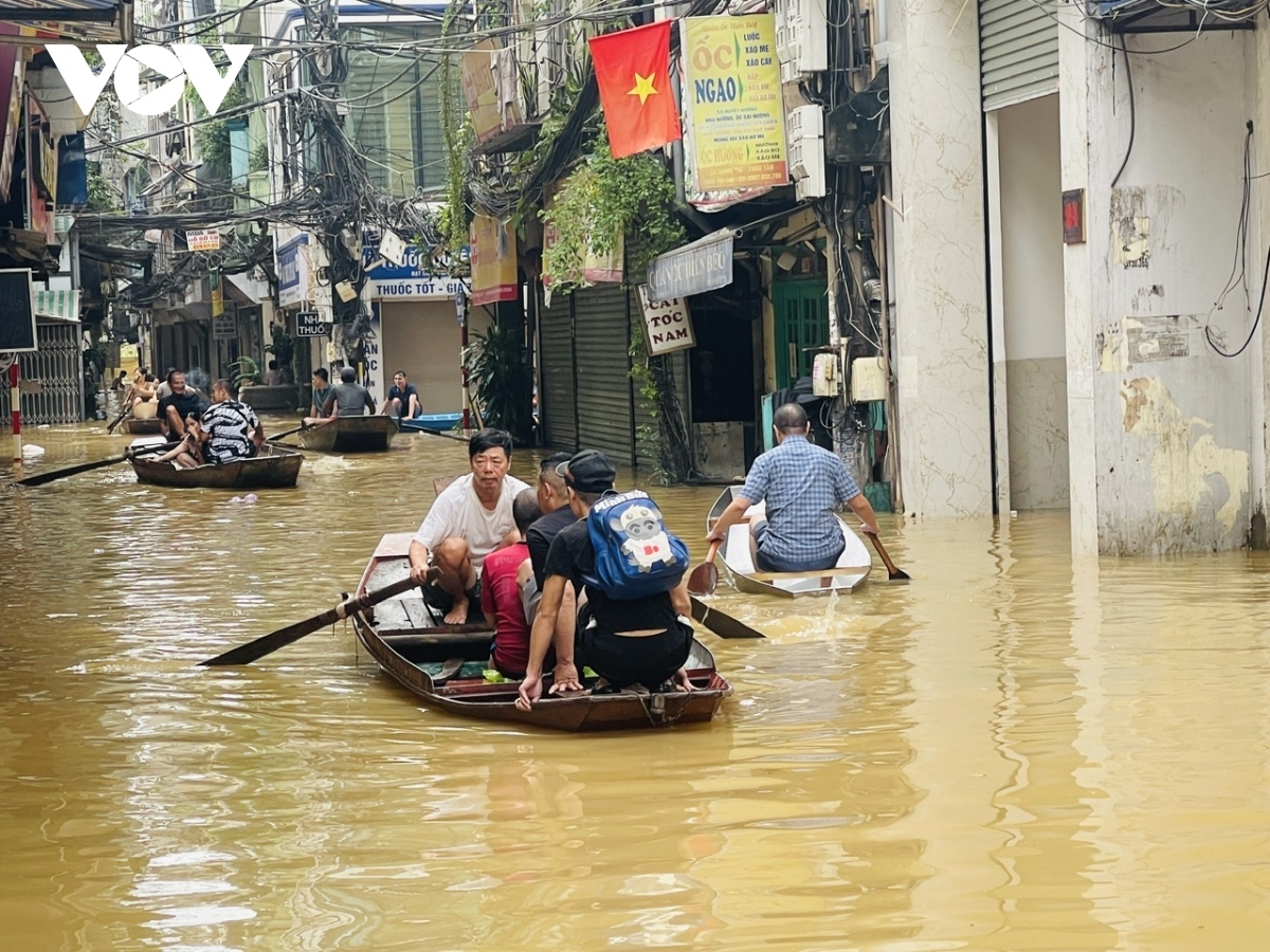 as floodwaters rise, hanoians use boats for transportation, daily activities picture 2