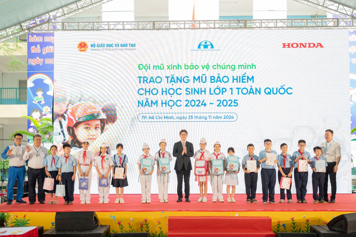 Ông Shinsuke Horiuchi - Phó Tổng Giám đốc Công ty Honda Việt Nam chụp ảnh cùng các em học sinh đạt giải trong phần thi Đào tạo lý thuyết