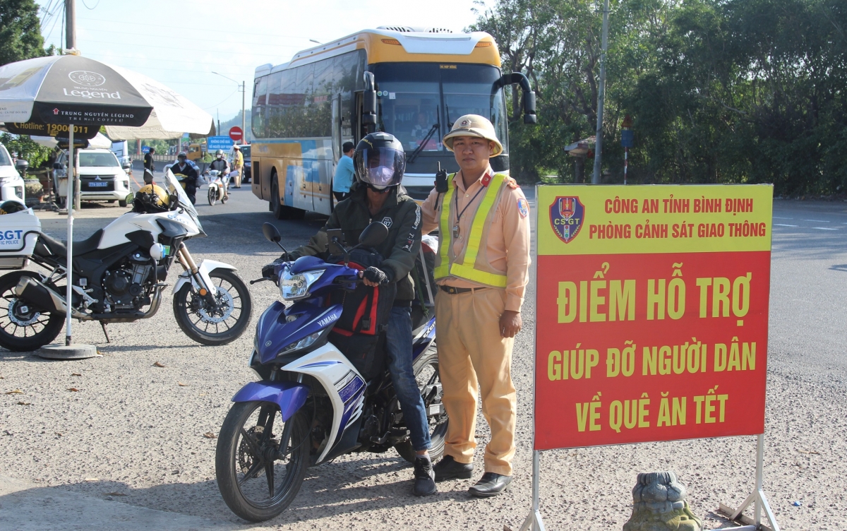 canh sat giao thong binh Dinh ho tro nguoi dan tren duong ve que don tet hinh anh 2