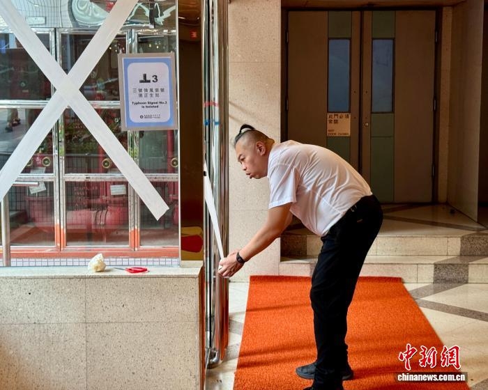 Nhân viên ban quản lý một khu dân cư tại Hồng Kông sử dụng băng dính gia cố cửa ra vào và cửa sổ trước bão Wipha. Ảnh: Chinanews Nhân viên ban quản lý một khu dân cư tại Hồng Kông sử dụng băng dính gia cố cửa ra vào và cửa sổ trước bão Wipha. Ảnh: Chinanews
