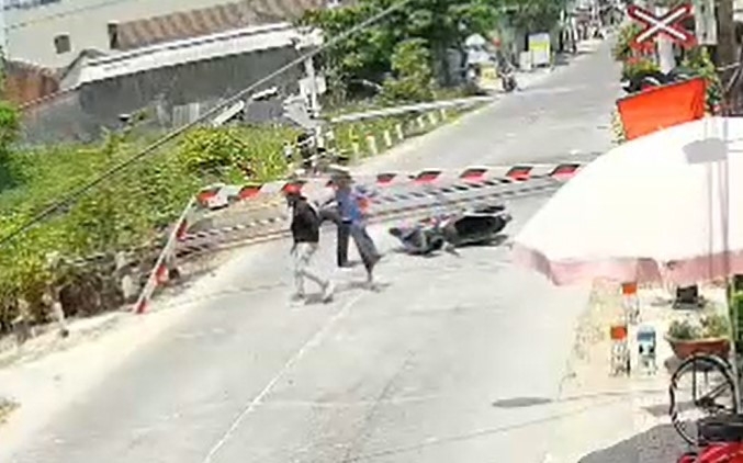 nguoi dan ong lao xe may tong gay gac chan khi tau sap chay qua hinh anh 2