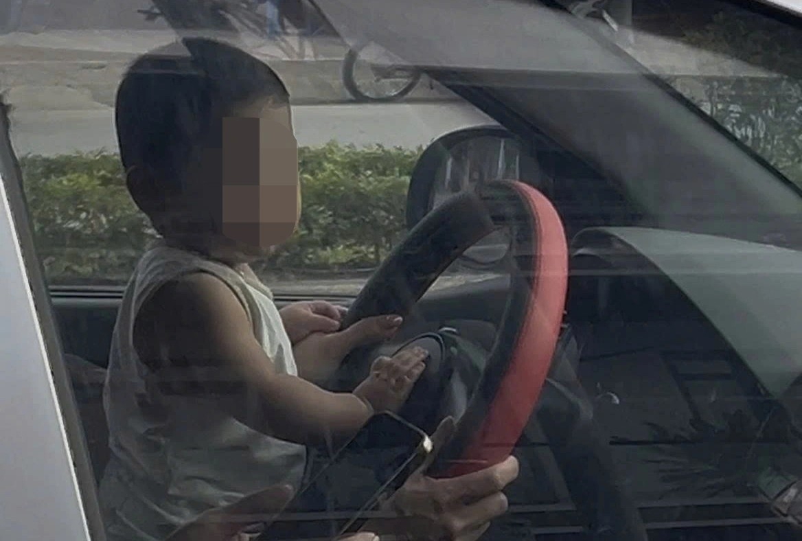 csgt ha noi xu phat voi nu tai xe de tre nho cam vo lang khi xe dang di chuyen hinh anh 2