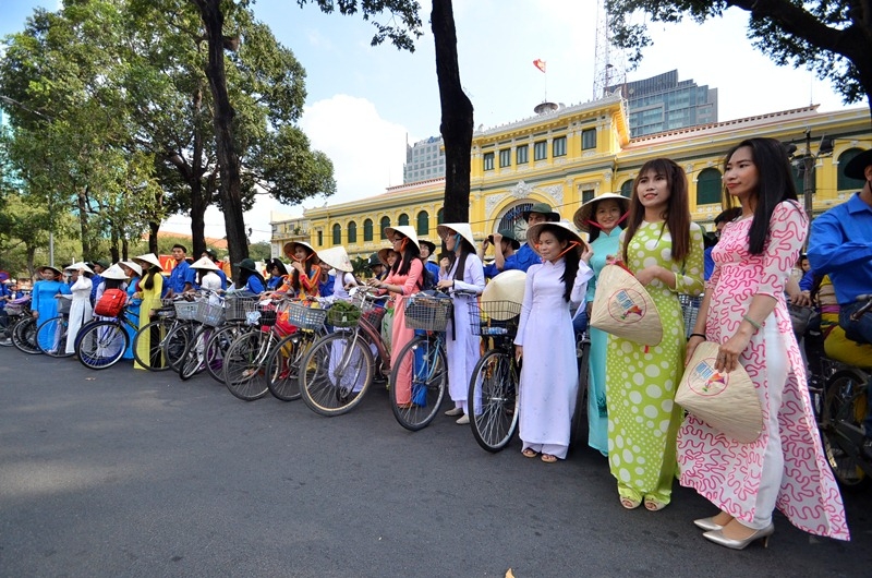 Students in “Ao Dai” costume cycle downtown HCM City