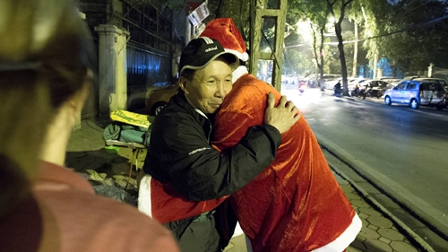 Youth wearing Santa Claus outfits on motorbikes deliver Christmas cheer