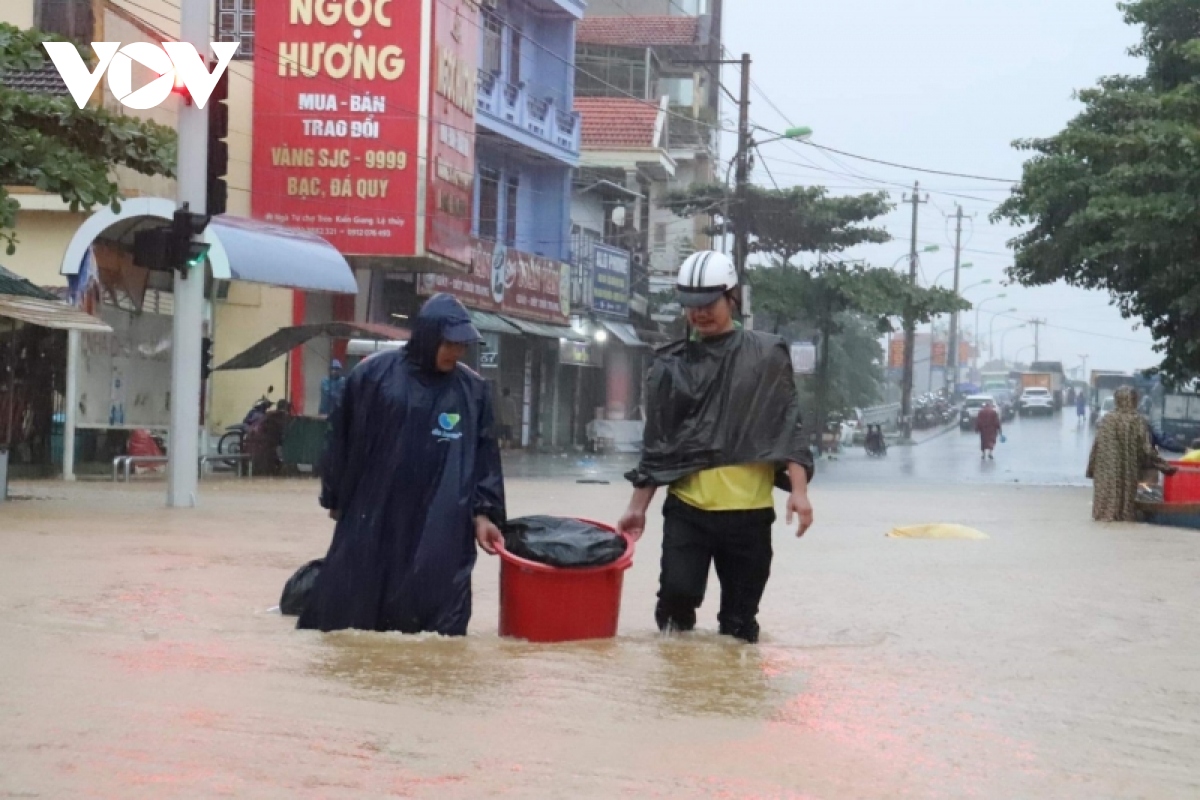 nuoc lu o quang binh len nhanh, pho bien thanh song, nguoi dan cheo ghe tren duong hinh anh 4