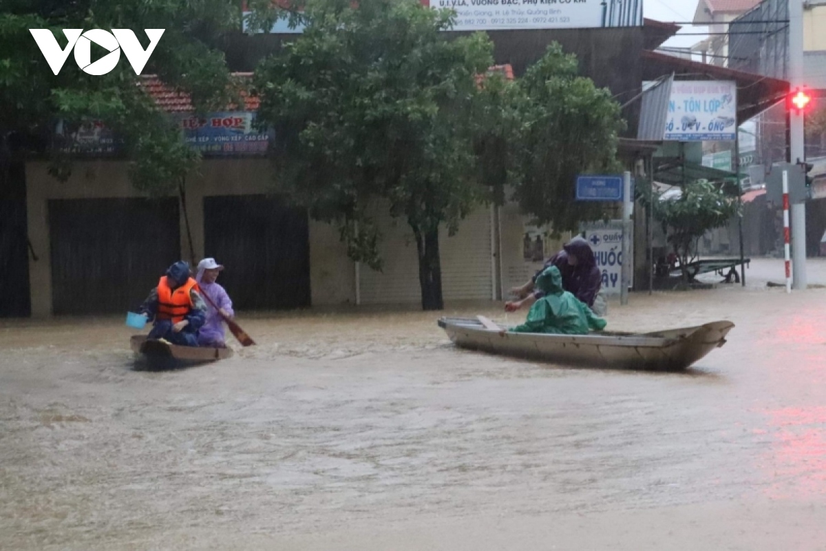 nuoc lu o quang binh len nhanh, pho bien thanh song, nguoi dan cheo ghe tren duong hinh anh 9