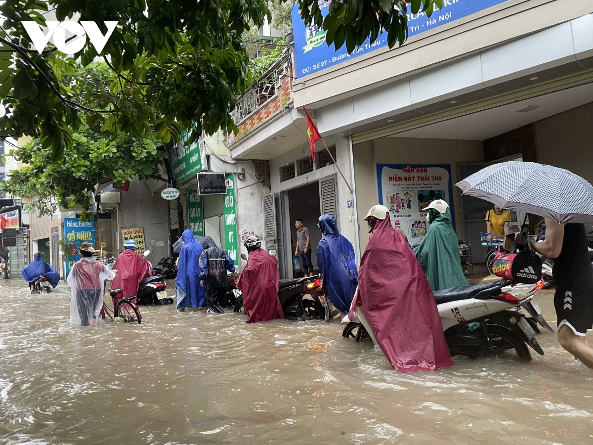 can canh nguoi va xe bi bom tren pho phuong ha noi sau mua lon keo dai hinh anh 1