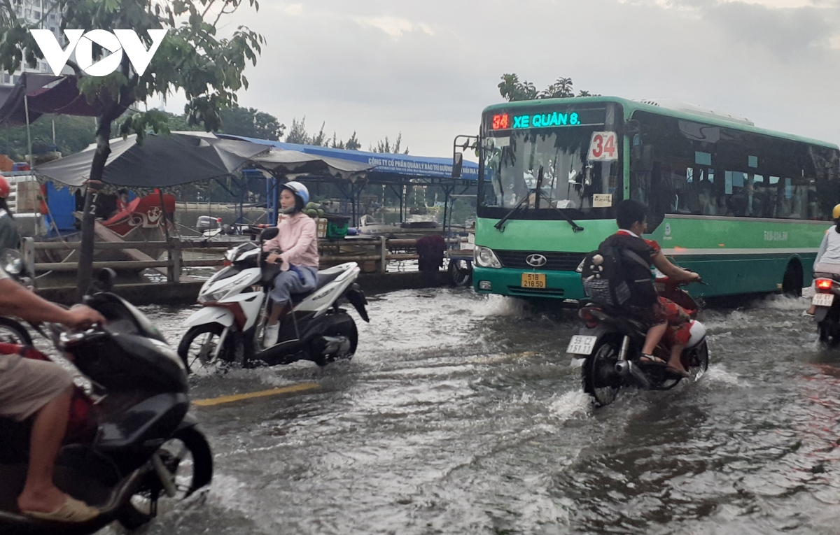 Triều cường dâng cao, người dân ở TP.HCM lội nước về nhà sau giờ tan tầm