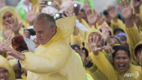 Giáo hoàng Francis mặc áo mưa đưa tay chào giáo dân ở thành phố Tacloban. (Ảnh: AFP)