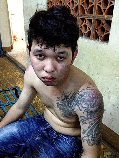 Nguyễn Phú Quý với hình xăm con rồng quấn quanh vai, bị bắt tại cơ quan công an